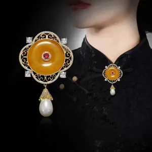 Broche qipao style cour avec boucle de sécurité jaune, pierre rouge et pendentif perle.