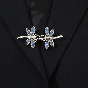 Primo piano della clip per cardigan a doppia libellola in metallo argentato con strass blu.