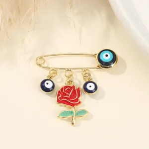 Gold-tone safety pin brooch featuring blue evil eye beads and red rose enamel pendant for women.