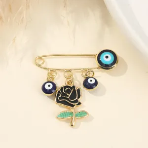 Detailed close-up of a creative fashion brooch featuring blue evil eye charms and black rose.