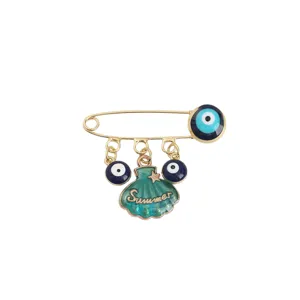 Broche épingle de sûreté œil maléfique chic avec pendentif coquillage émail vert et lettres.