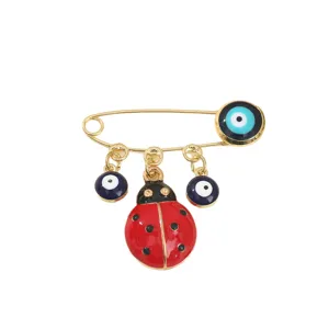 Gold safety pin brooch featuring cute ladybug charm and evil eye blue beads fashion jewelry