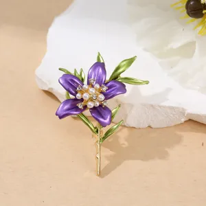 Nahaufnahme einer prunkvollen lila Blumenbrosche mit Perlen und grünen Blättern.