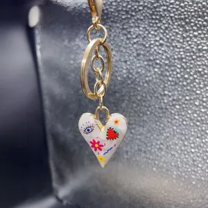 Alloy enamel heart keychain detail showing colorful doodle pattern and gold tone metal rings.
