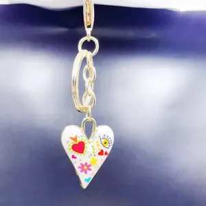 Close-up of alloy heart pendant keychain with colorful enamel details, stylish bag accessory.
