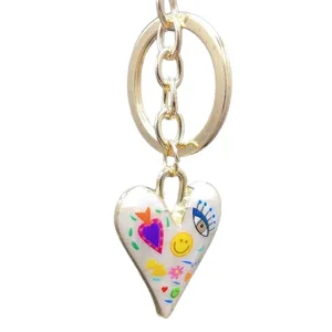 Golden alloy keychain featuring a colorful enamel heart pendant with trendy graffiti style charms.