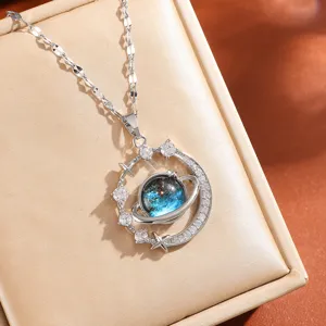 Closeup of a gorgeous galaxy planet necklace with sparkling cubic zirconia and blue cosmic pendant.