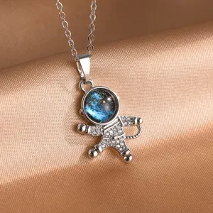 Close-up detail of silver astronaut pendant necklace with starry galaxy dome, delicate chain.