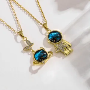 Detailed close-up of the blue galaxy astronaut and planet necklaces with crystals.
