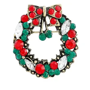 Detaillierte Nahaufnahme der Vintage Weihnachts-Kranz Strass Brosche mit roten und grünen Steinen.