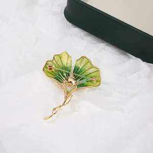 Detailed close-up of the back of a green enamel ginkgo leaf brooch with gold plated pin.