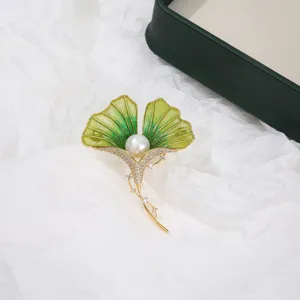Exquisite ginkgo leaf enamel brooch detailed with sparkling rhinestones and a central pearl.