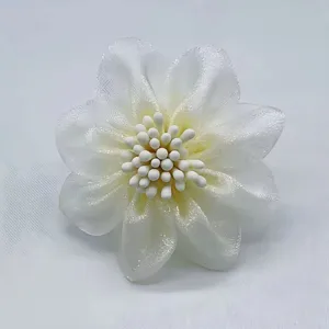 Détail de broche fleur en tulle blanc, élégante épingle florale en tissu pour femmes.