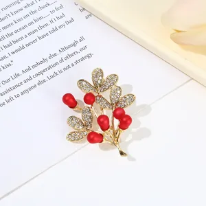 Elegant gold-tone rhinestone leaf and red berry brooch pin for women fashion clothing.