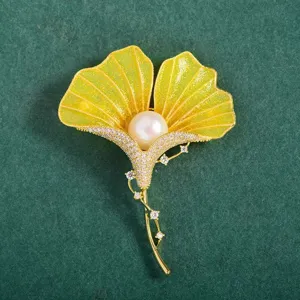 Ginkgo leaf brooch detail, yellow enamel design with central pearl and rhinestone accents.