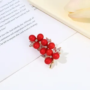Detailed shot of exquisite red pearl rhinestone brooch pin, elegant design for women outfits.