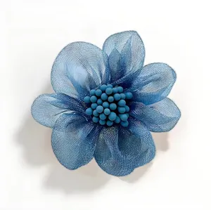Détail de broche fleur en tulle bleu exquis, avec tissu maille et cœur perlé.