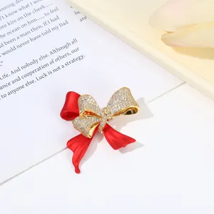 Exquisite red bow rhinestone brooch detail, sparkling crystal and matte red ribbon design.