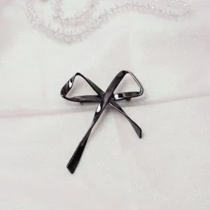 Dettaglio ravvicinato di un'elegante spilla a fiocco in metallo nero e raffinata.