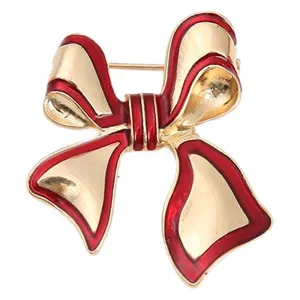 Elegante spilla a fiocco dorata con dettaglio in smalto rosso vivo accessorio di moda raffinato