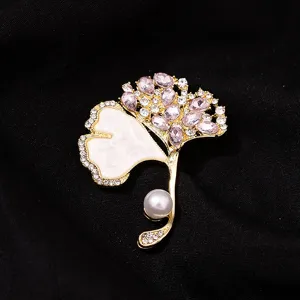 Exquisite ginkgo leaf brooch featuring sparkling rhinestones and an elegant pearl. Perfect detail.