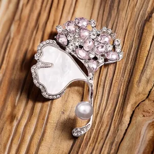 Elegant ginkgo leaf brooch with sparkling pink rhinestones, faux pearl, and chic metallic finish.