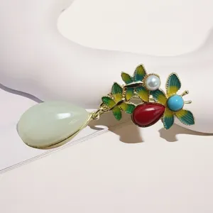 Close-up detail view of vintage style alloy enamel teardrop brooch with faux jade stone.