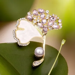 Exquisite ginkgo leaf brooch detail, gold-tone metal, sparkling pink crystals and elegant pearl.