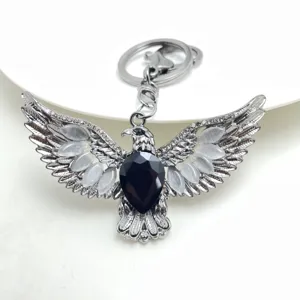 Detailed shot of retro eagle wing keychain with black gemstone and cat's eye stones.