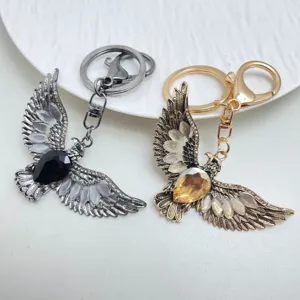 Vintage eagle keychain with cat's eye stone and teardrop gem, stylish metal bag charm.