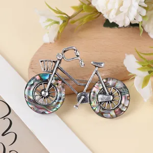Detailed view of vintage alloy bicycle brooch featuring colorful abshell wheels and crystal accent.