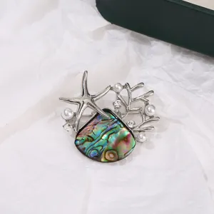 Exquisito detalle de broche de estrella de mar y concha con nacre colorida y perlas.