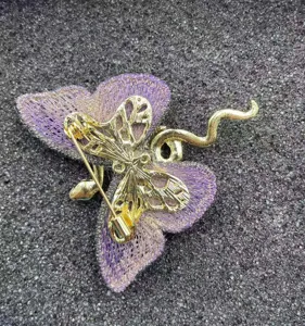Detailed back view of a luxury blue-purple embroidered butterfly and gold snake brooch pin.