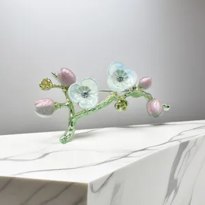 Exquisite floral branch brooch detailed close-up, elegant enamel flower design with sparkling rhinestones.