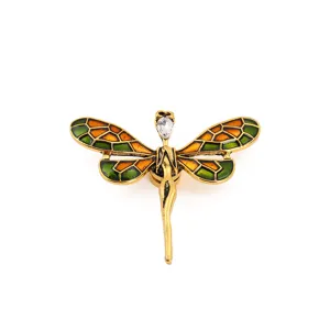 Close-up of a gold dragonfly brooch with colorful enamel mosaic and sparkling rhinestone head.