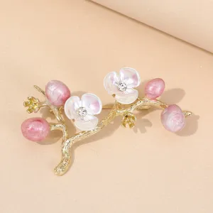 Exquisite floral brooch featuring gold branches, pink pearlescent buds, and sparkling crystal.