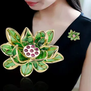 Vue détaillée d'une broche lotus style chinois exquise avec émail vert et cristaux rouges.