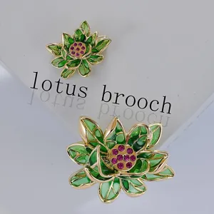 Gros plan détail de broche lotus en émail vert avec centre en cristal rose et métal.