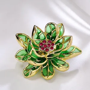 Vue détaillée de la broche fleur de lotus exquise avec émail vert et strass rouges éclatants.