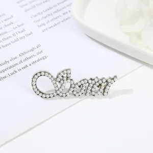 Pearl letter brooch detail shot, showing exquisite alloy texture and delicate faux pearls.