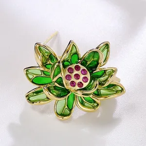 Détail en gros plan de l'élégante broche lotus verte avec centre en cristal rose et cadre doré.