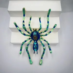 Hermosa broche de araña esmaltada con degradado verde y azul y pedrería brillante.