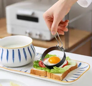 Detailed view of black stainless steel egg ring mold on sandwich toast, ideal for breakfast cooking.