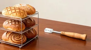 Holzgriff Brotlamme Edelstahl Teigschneidewerkzeug Detailansicht fuer handwerkliches Backen.