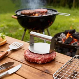 Pressa per hamburger in acciaio inox, dettaglio superficie liscia, robusto strumento.