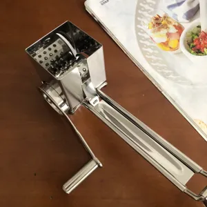Stainless steel manual rotary cheese grater detail shot, kitchen shredder tool for cheese.