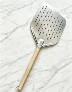 Stainless steel perforated pizza peel with wooden handle, ideal for baking and transferring.