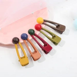 Primo piano dettagliato di colorati fermagli per capelli con graziosi dettagli rotondi.