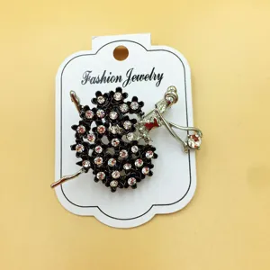 Primo piano della simpatica spilla ballerina di cristallo su cartoncino bianco, strass