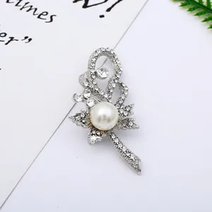 Detailed shot of sparkling rhinestone and pearl alloy brooch, elegant jewelry.